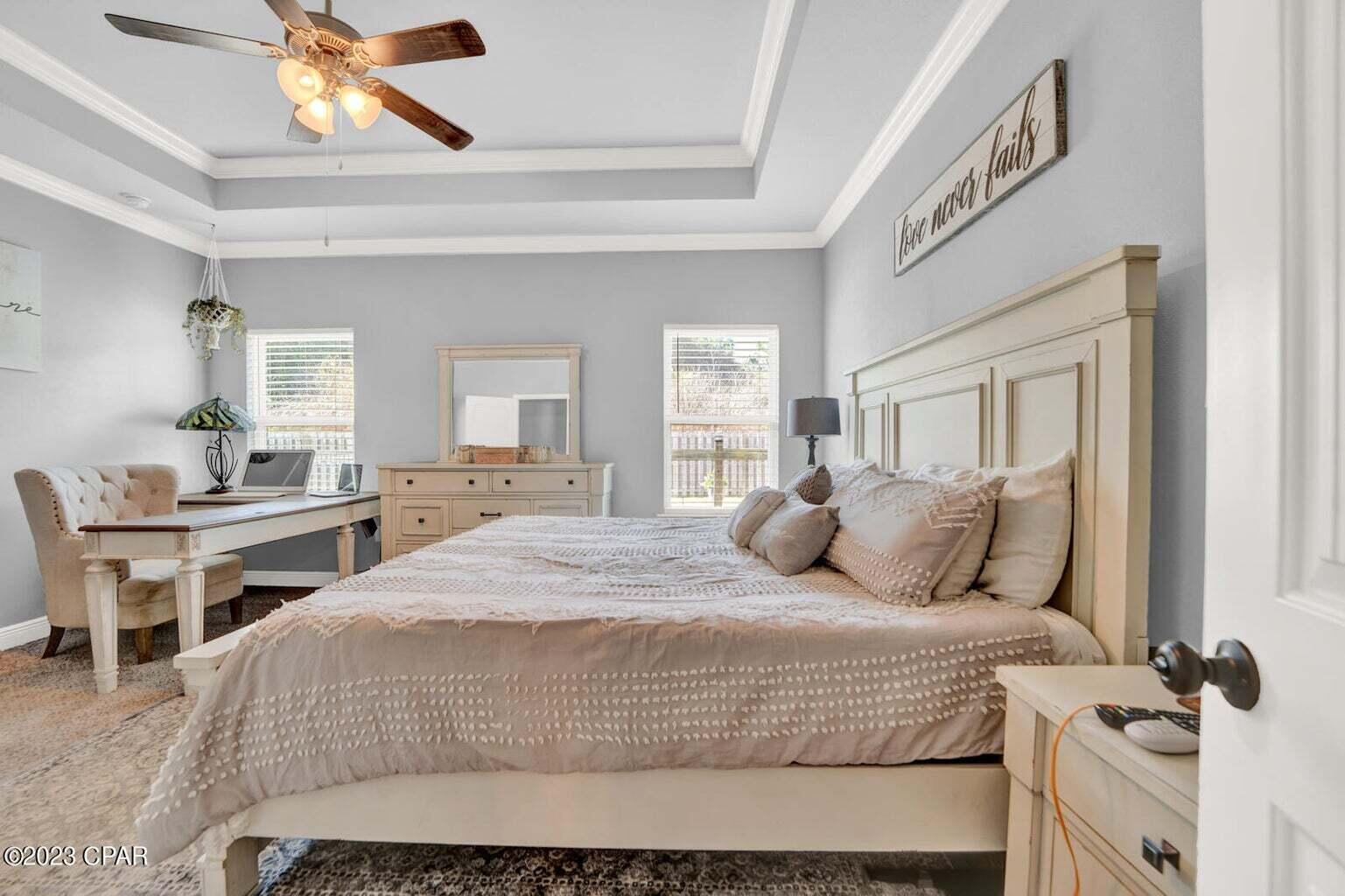 622 Cornelia Street Freeport, FL 32439 - Photo 11 of 43 a bedroom with a large bed and a chandelier