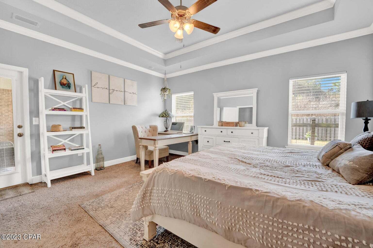 622 Cornelia Street Freeport, FL 32439 - Photo 12 of 43 a bedroom with a bed a large window and a chandelier