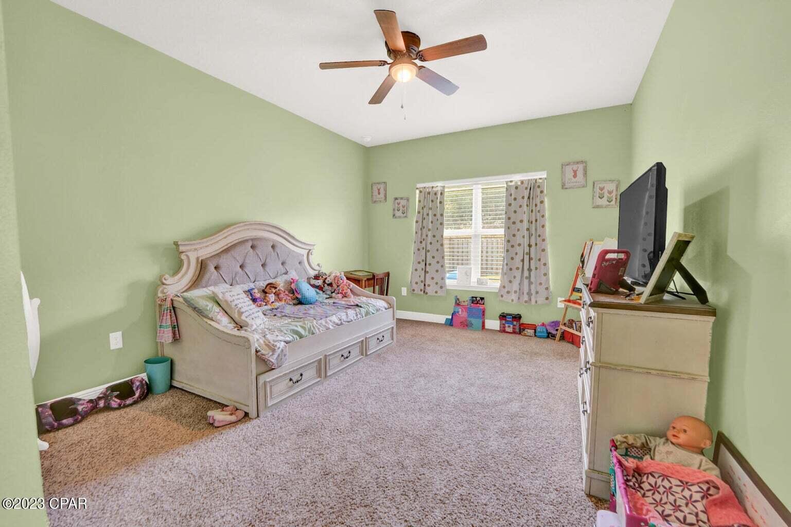 622 Cornelia Street Freeport, FL 32439 - Photo 36 of 43 a bedroom with a bed and a chandelier