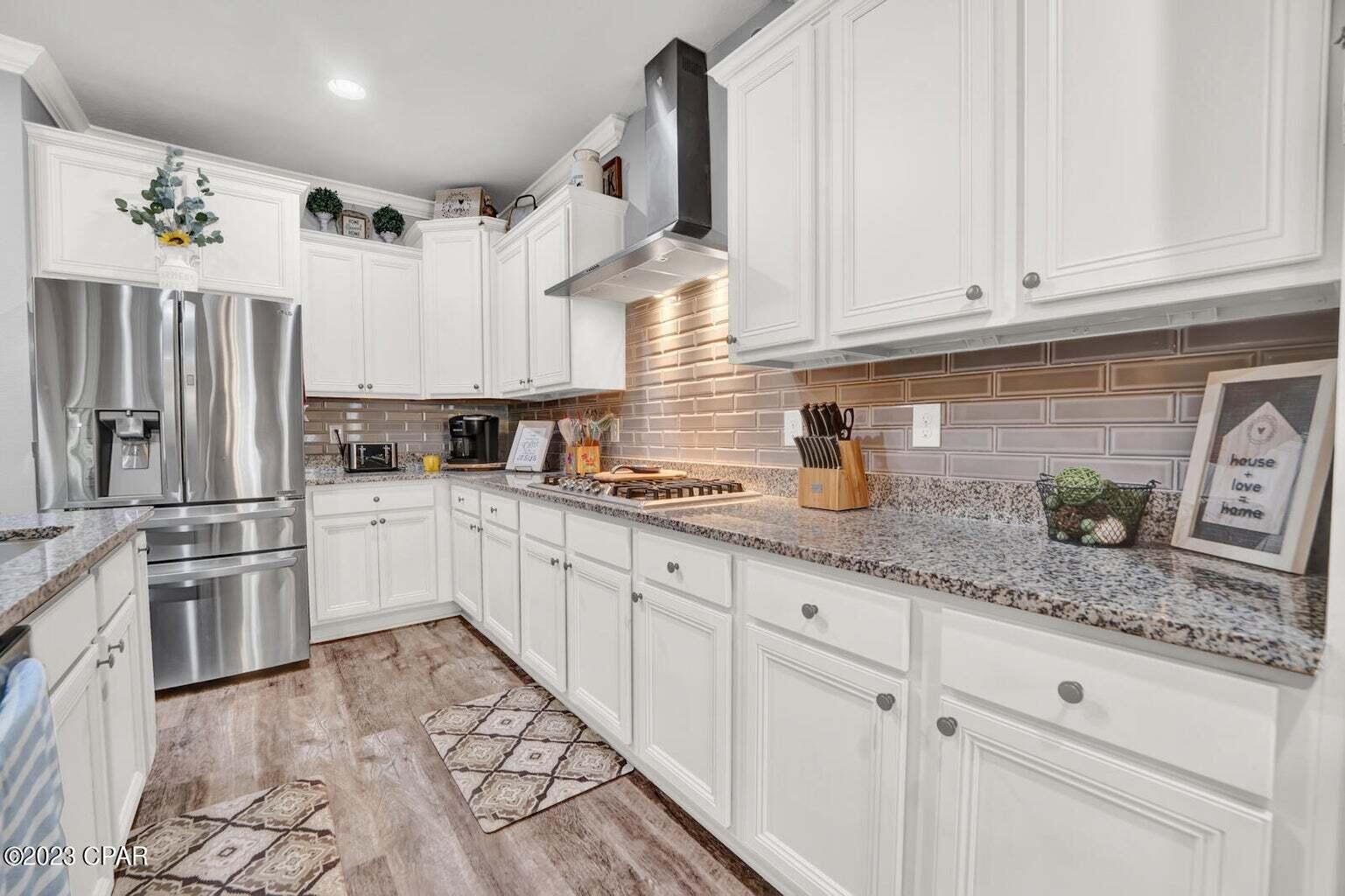 622 Cornelia Street Freeport, FL 32439 - Photo 5 of 43 a kitchen with stainless steel appliances granite countertop a sink a stove and cabinets