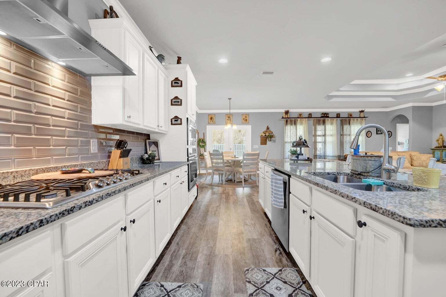 622 Cornelia Street Freeport, FL 32439 - Photo 7 of 43 a large kitchen with stainless steel appliances granite countertop a lot of counter space and wooden floors