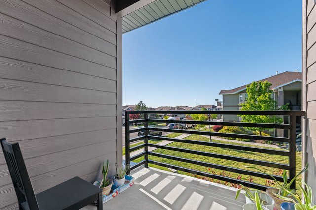 8307 Durham Street Sandy, UT 84070 - Photo 12 of 29 Private concrete patio with horizontal siding, a black metal railing, and a slatted ceiling