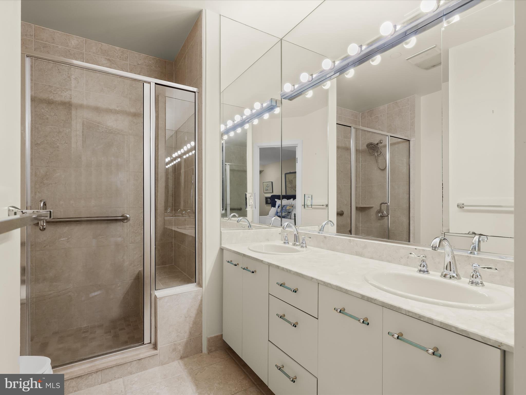 4001 Old Court Road, Unit 115 Baltimore, MD 21208 - Photo 18 of 31 a bathroom with a double vanity sink mirror double shower and a bathtub