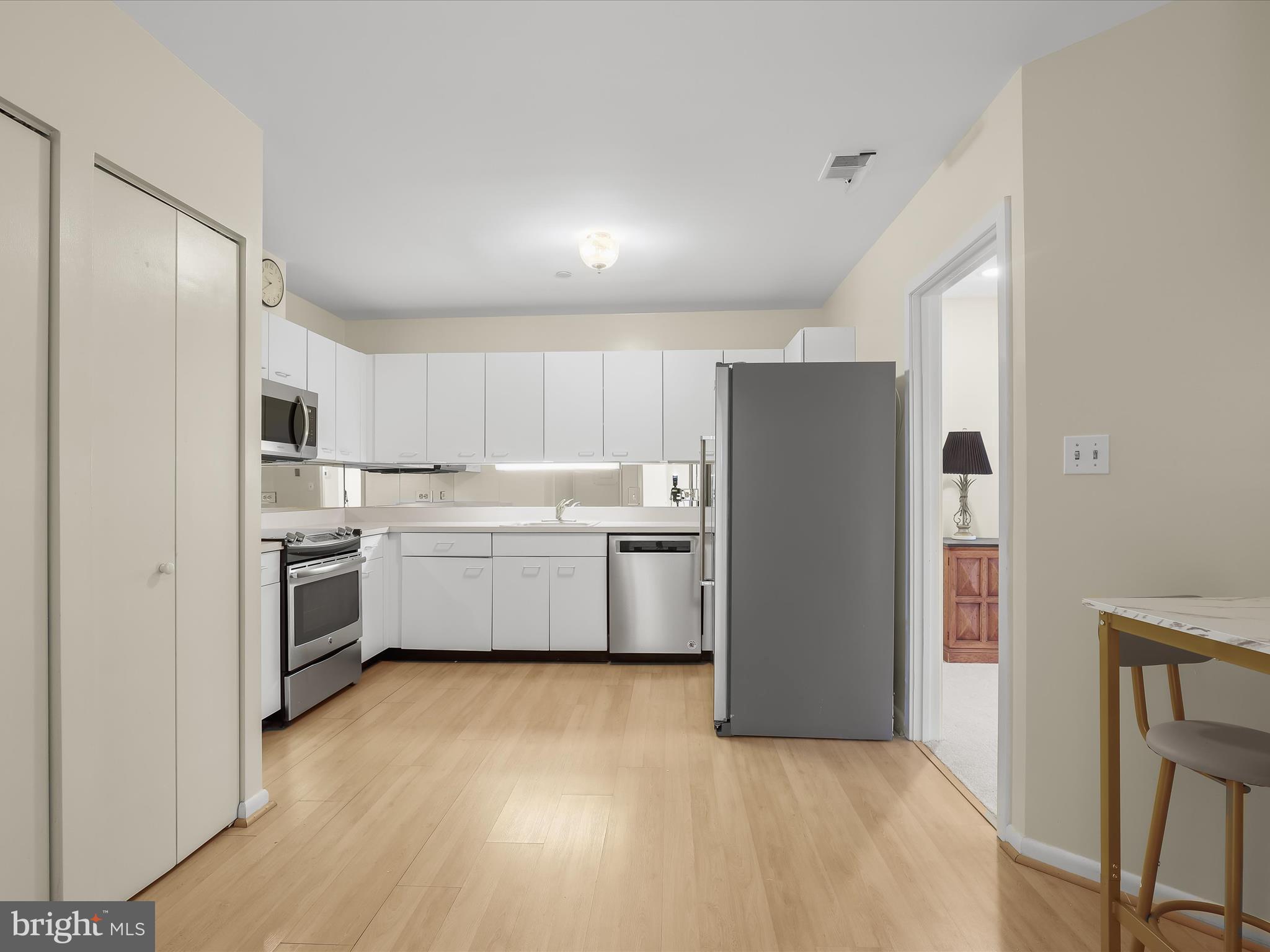 4001 Old Court Road, Unit 115 Baltimore, MD 21208 - Photo 5 of 31 a kitchen with a cabinets a sink stainless steel appliances and wooden floor