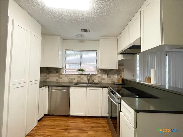 a kitchen that has a sink and a stove in it