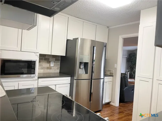 a kitchen with stainless steel appliances a refrigerator microwave and sink