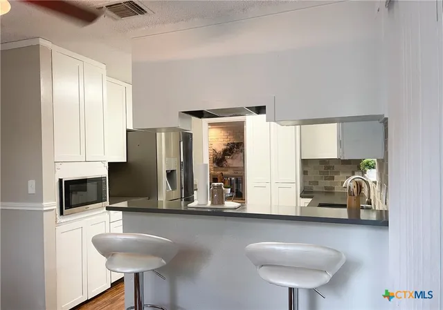 a kitchen with stainless steel appliances a sink cabinets and wooden floor