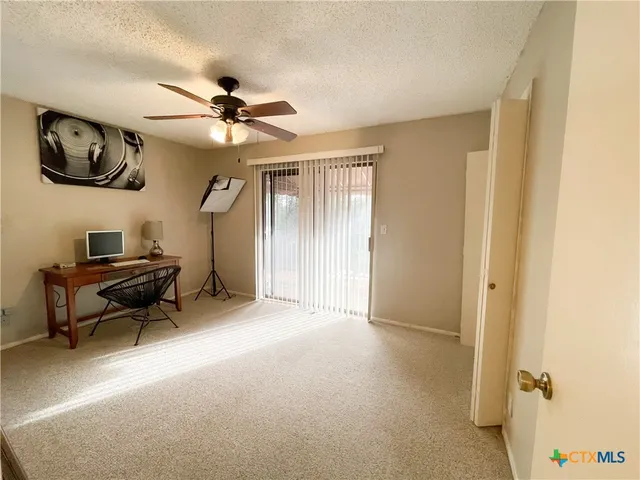 a view of a livingroom with furniture and a ceiling fan