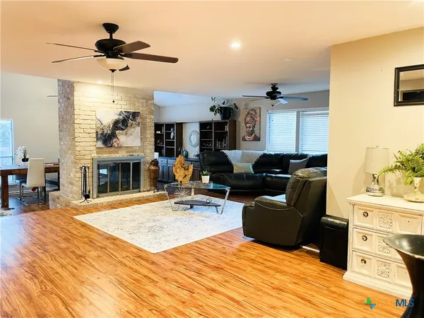 a living room with furniture a fireplace and a chandelier