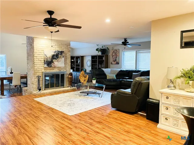 a living room with furniture a fireplace and a chandelier
