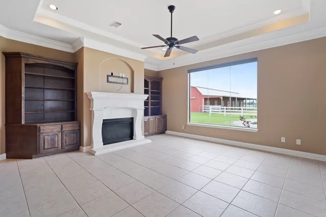 a view of an empty room with a fireplace and a window