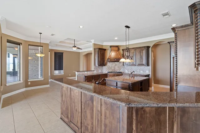 a large kitchen with granite countertop a sink and a refrigerator