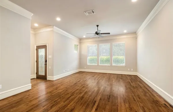 a view of empty room with wooden floor