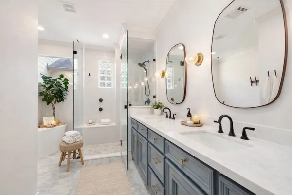 a bathroom with a tub shower sink and mirror