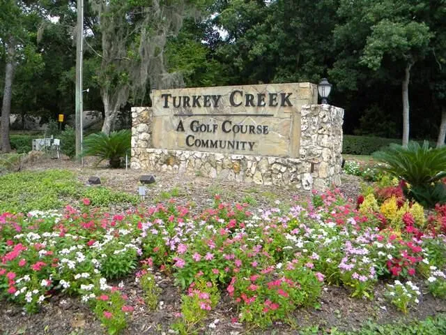 a sign that is sitting in front of flowers
