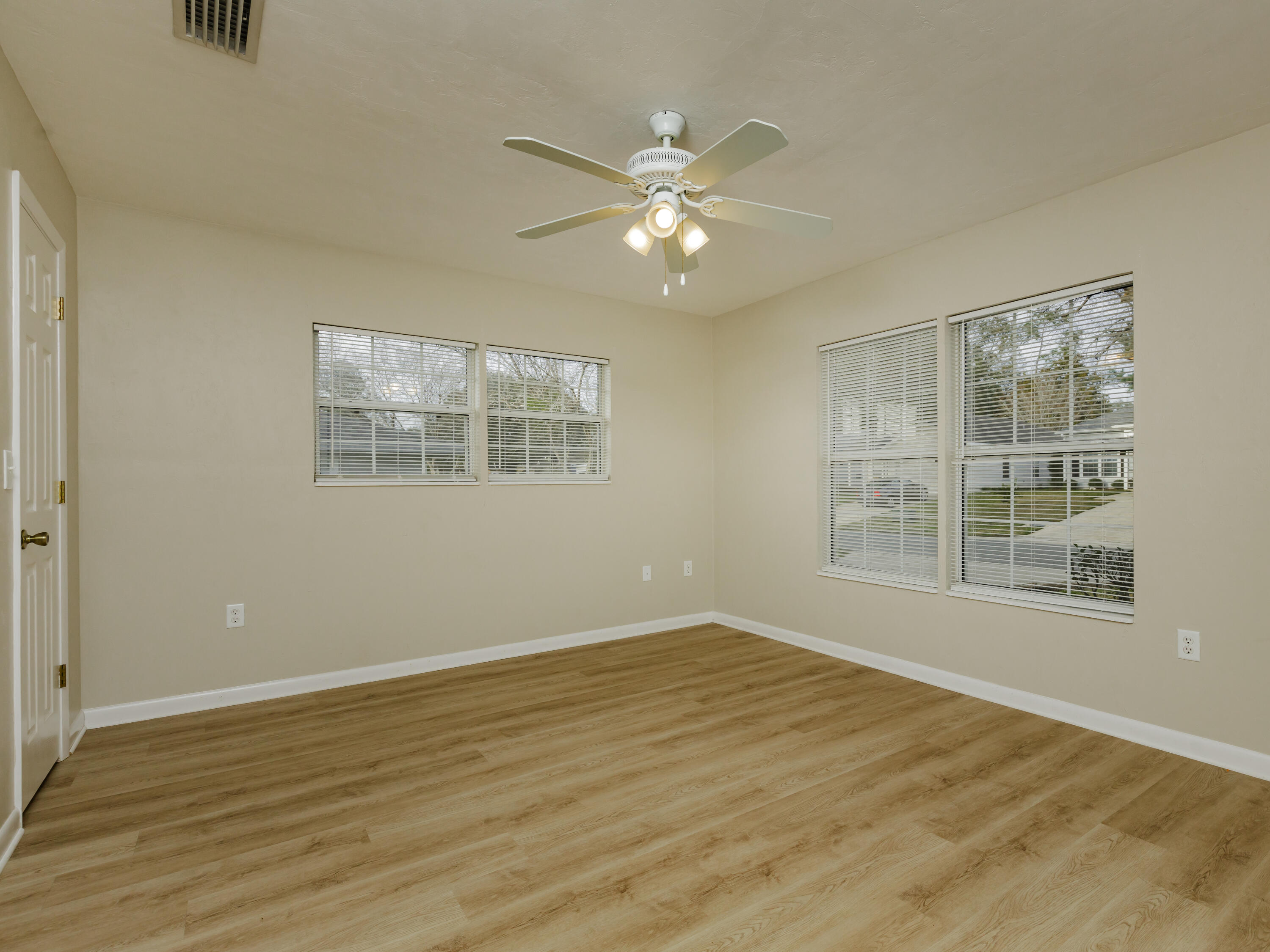 6367 Northwest 109th Place Alachua, FL 32615 - Photo 5 of 15 a view of an empty room with wooden floor and a window