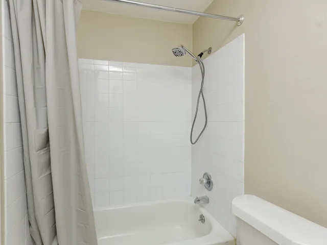 a bathroom with a bath tub with a shower