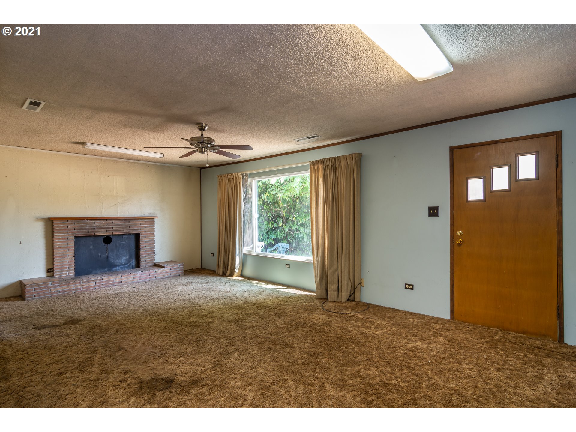 4200 Nonpareil Road Sutherlin, OR 97479 - Photo 4 of 32 a view of an empty room with a fireplace and a window