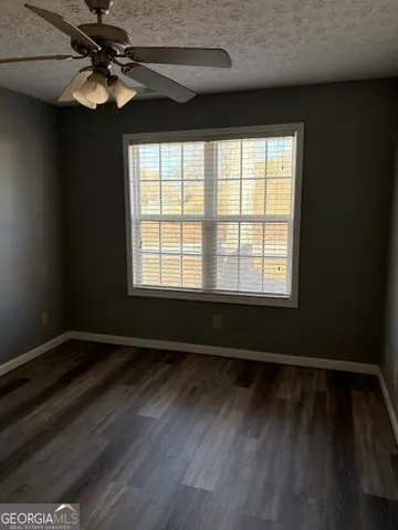 a view of an empty room with window and wooden floor