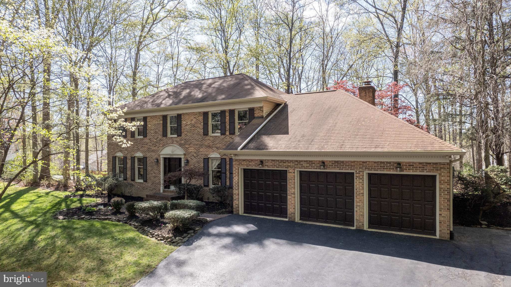 a view of a house with a yard and large tree