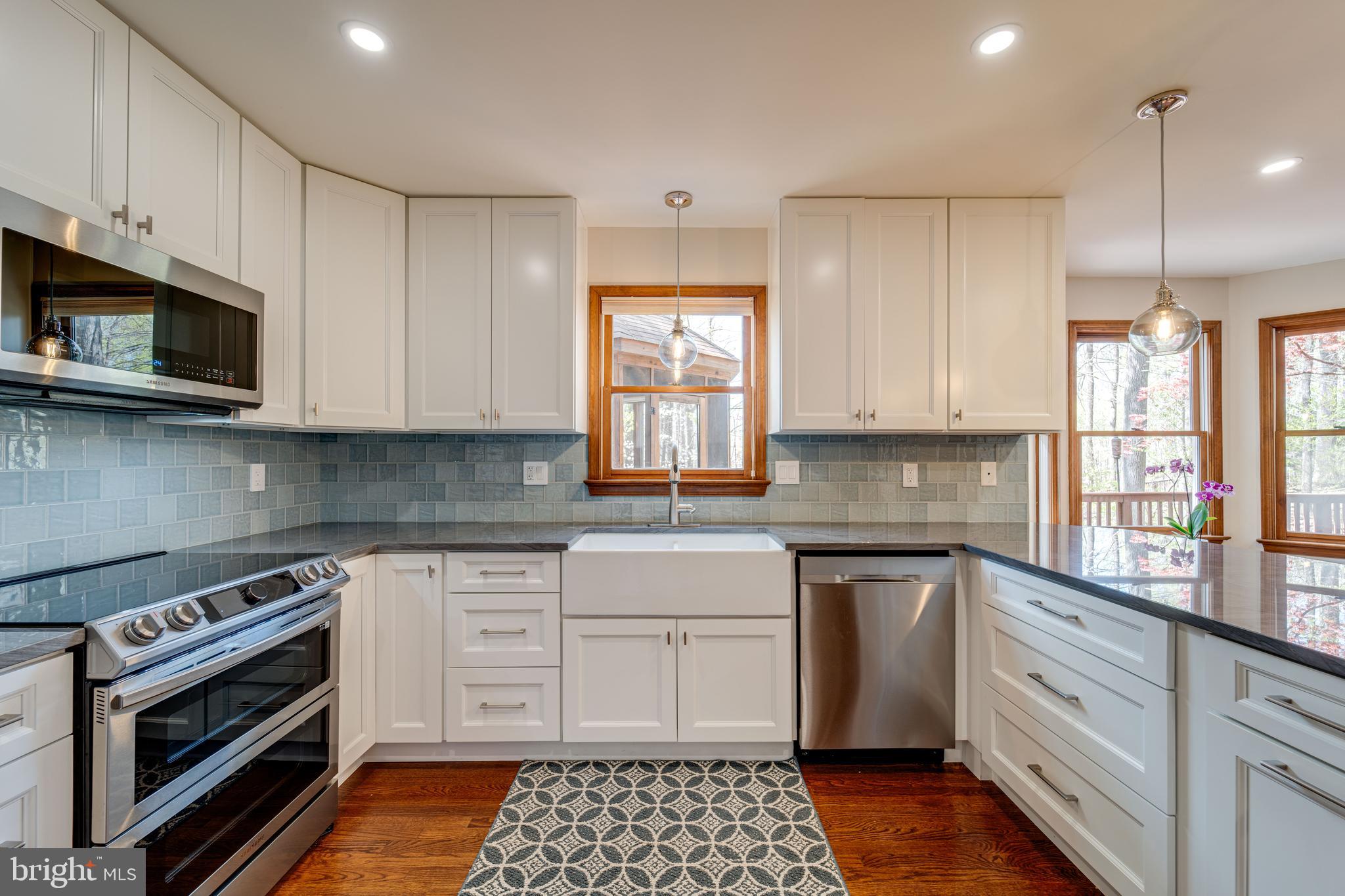 8232 Honeysuckle Road Manassas, VA 20112 - Photo 22 of 76 a kitchen with stainless steel appliances granite countertop a stove a sink and a microwave