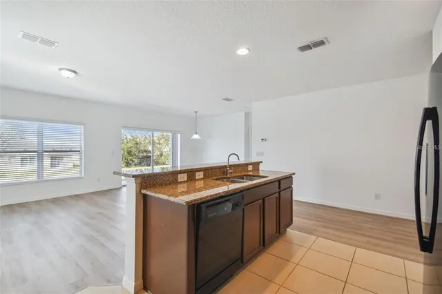 a kitchen with stainless steel appliances granite countertop a stove a sink and a refrigerator