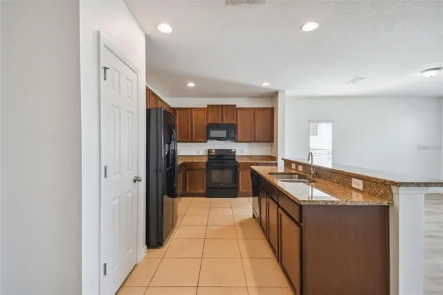 a kitchen with stainless steel appliances kitchen island sink refrigerator and window