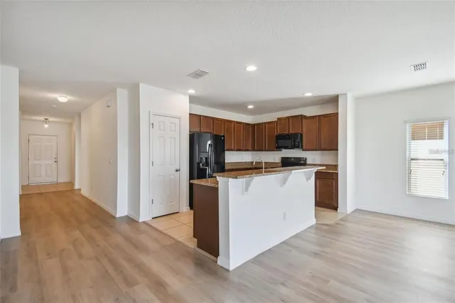 a view of kitchen island a sink a counter space and a window