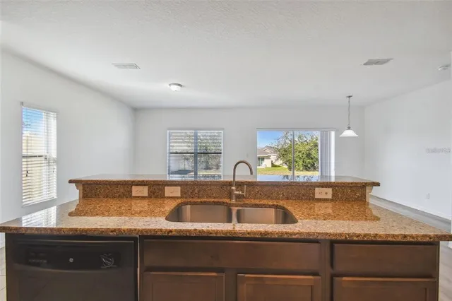 a kitchen with stainless steel appliances granite countertop a refrigerator a stove top oven a sink and dishwasher