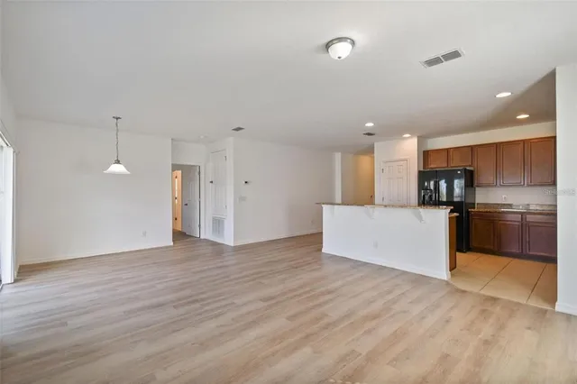 a view of a kitchen with a sink wooden cabinets and stainless steel appliances
