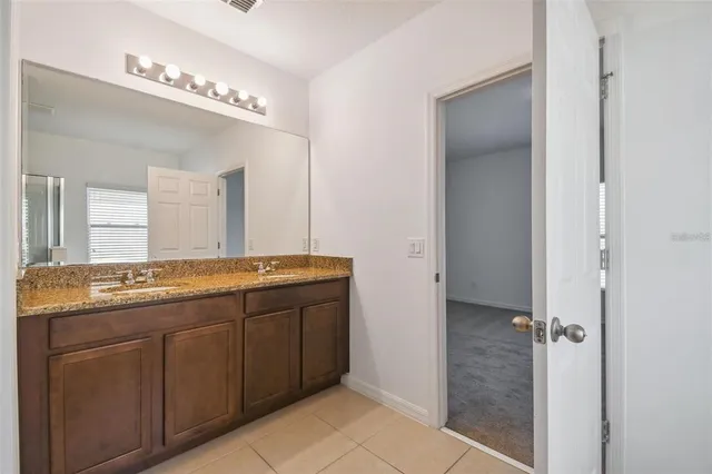 a bathroom with a granite countertop sink a mirror and a shower
