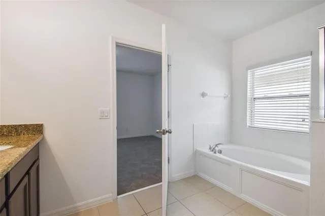 a bathroom with a bathtub a window and a shower
