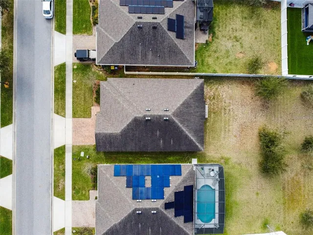 an aerial view of residential houses with outdoor space and parking