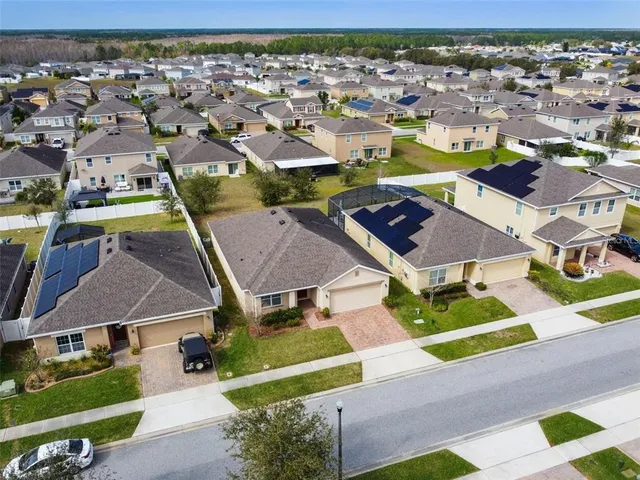 an aerial view of multiple houses with a yard