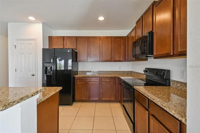 a kitchen with stainless steel appliances granite countertop a stove a sink and a refrigerator