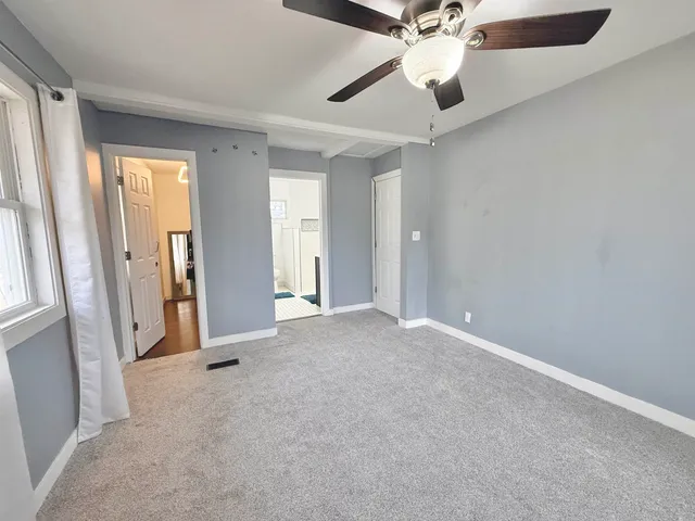 an empty room with closet and a chandelier fan