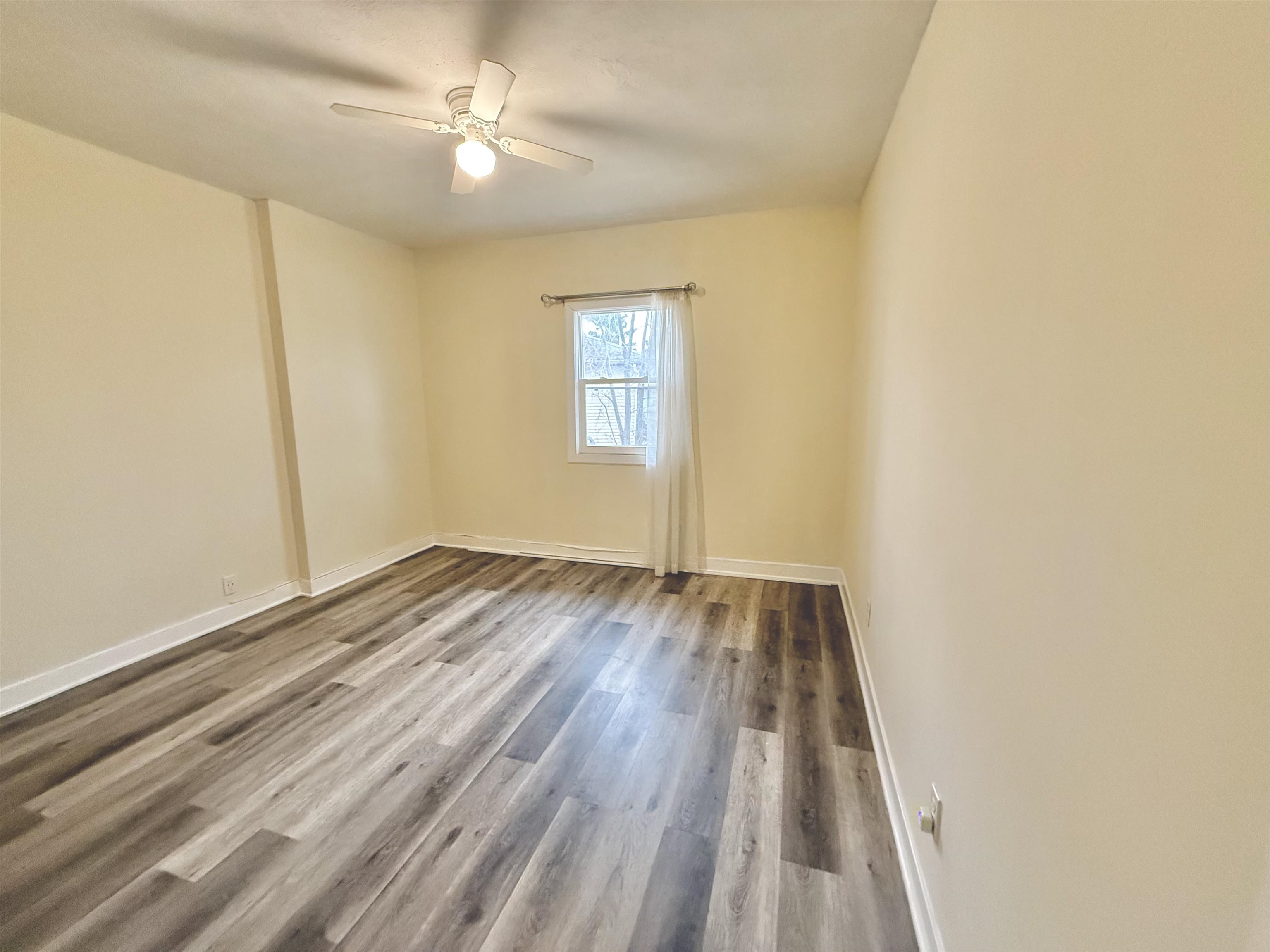 8432 Ravere Street Machesney Park, IL 61115 - Photo 19 of 31 wooden floor in an empty room with a window
