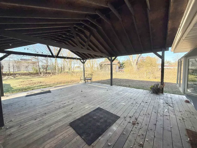 a view of an empty room with wooden floor and a floor to ceiling window