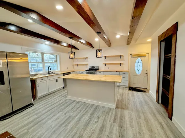 a kitchen with stainless steel appliances granite countertop a lot of counter space and wooden floors