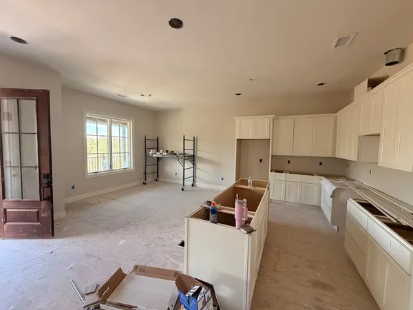 a living room with stainless steel appliances kitchen island granite countertop a sink and cabinets