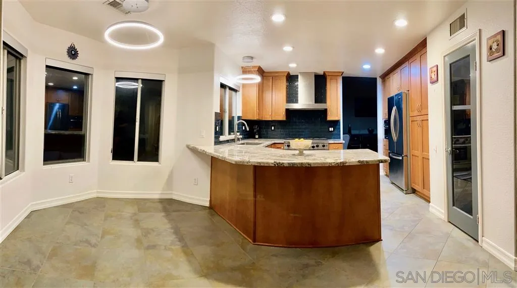 13609 Sunset View Road Poway, CA 92064 - Photo 3 of 15 a room with stainless steel appliances kitchen island granite countertop a refrigerator a sink a stove and oven