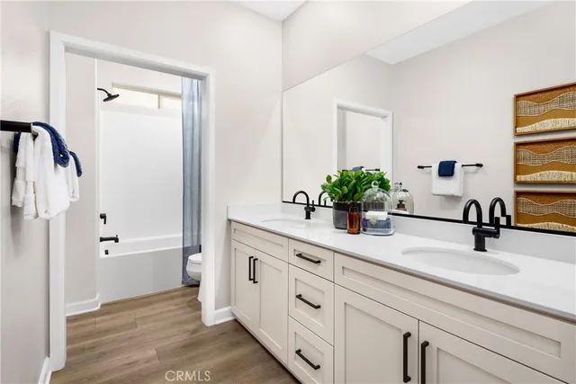 a bathroom with a double vanity sink a mirror and a bathtub