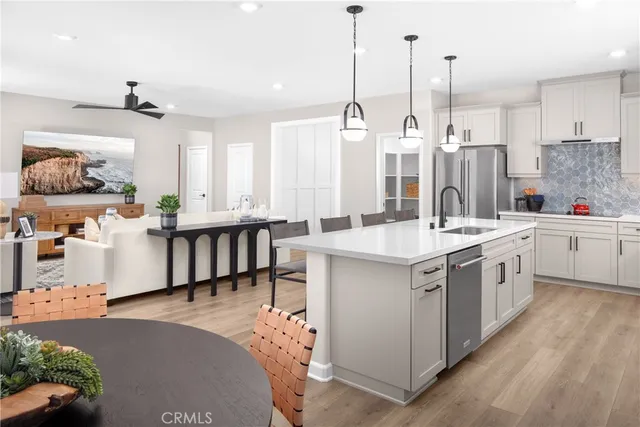 a kitchen with stainless steel appliances kitchen island granite countertop a sink a stove and a wooden floors