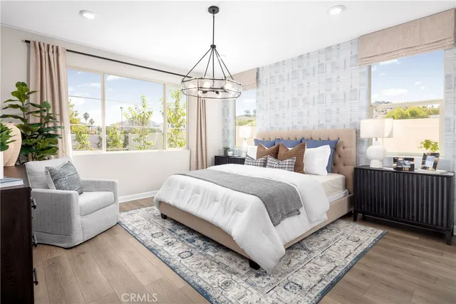 a bedroom with a large bed and a chandelier