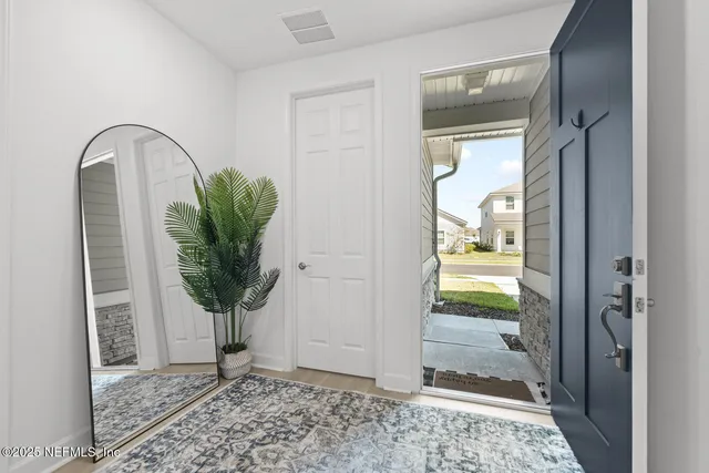 a kitchen with stainless steel appliances a stove a sink a microwave a refrigerator a stove and white cabinets