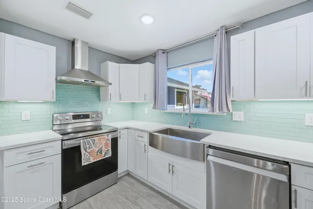 a kitchen with stainless steel appliances granite countertop a sink stove and cabinets