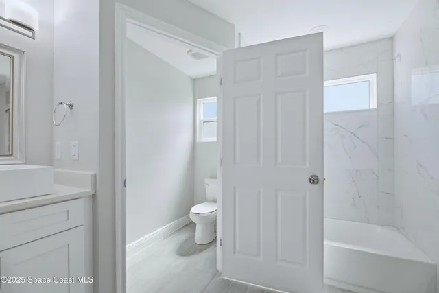 a bathroom with a shower a toilet and a sink