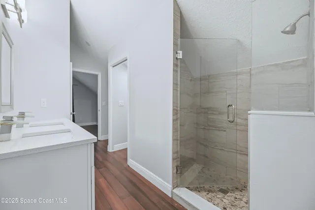 a bathroom with a sink mirror and shower