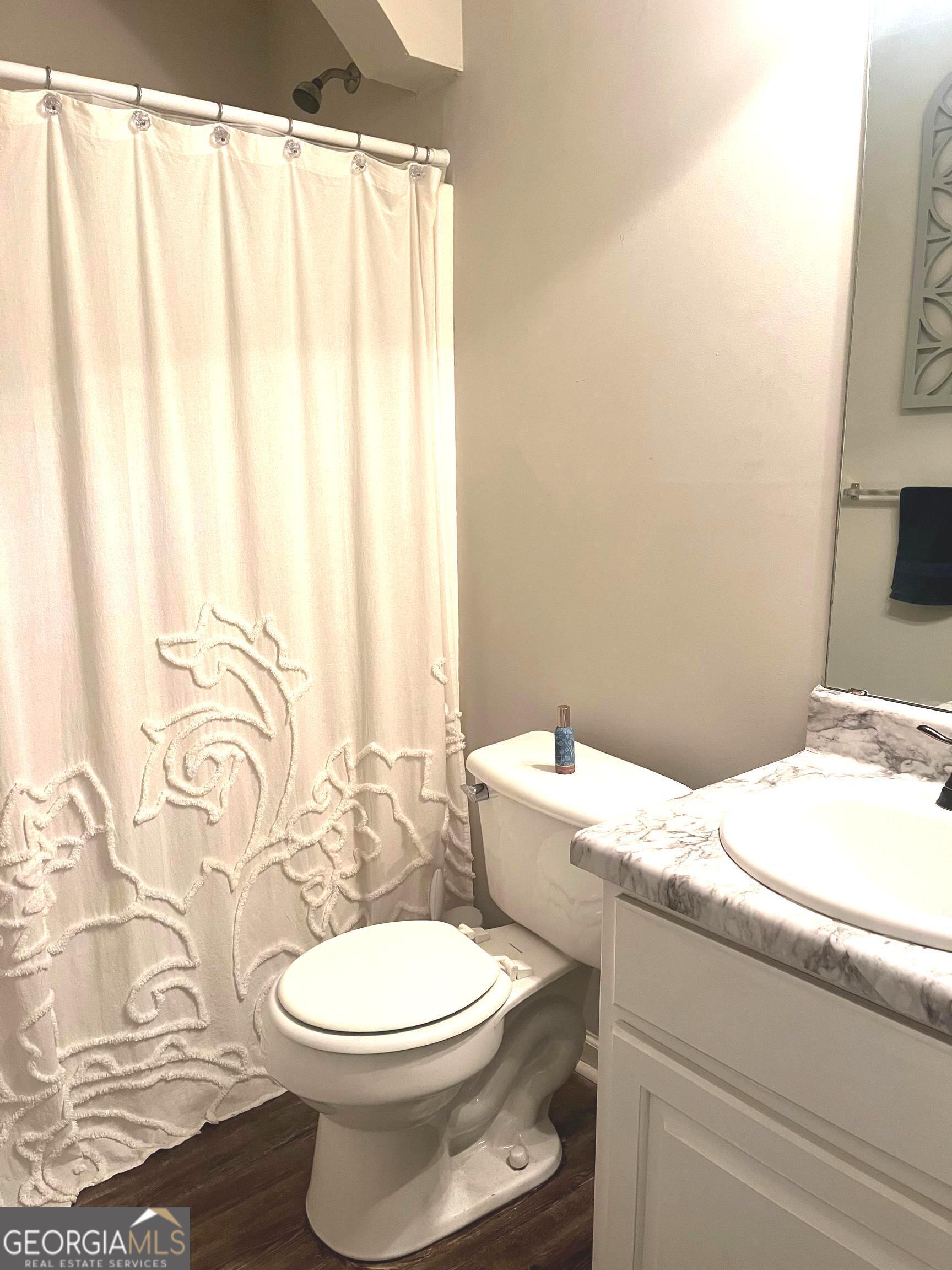 803 Lazy Lane Winder, GA 30680 - Photo 15 of 16 a bathroom with a granite countertop toilet and a sink