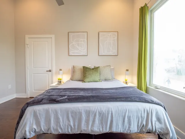 a spacious bedroom with a bed and a potted plant